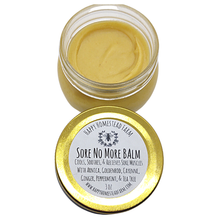 Load image into Gallery viewer, Open 3 oz glass jar of Sore No More Balm with golden balm and its labeled gold lid on a white background.